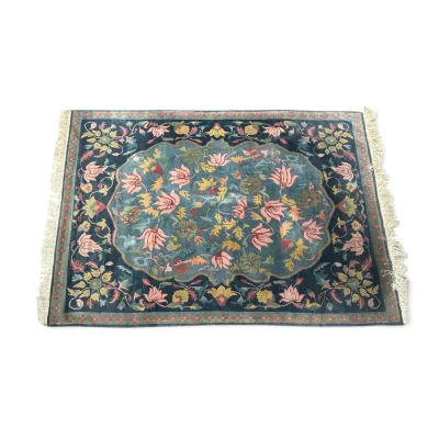 Sale Photo Thumbnail #298: Chinese Art Deco style wool rug featuring a central floral medallion in shades of pink, yellow, and green on a teal and navy blue ground, finished with fringed ends.
