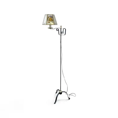 Sale Photo Thumbnail #201: Vintage wrought iron bridge arm floor lamp featuring a tripod base, scrollwork details, and a hexagonal paper shade with a winter scene illustration.
