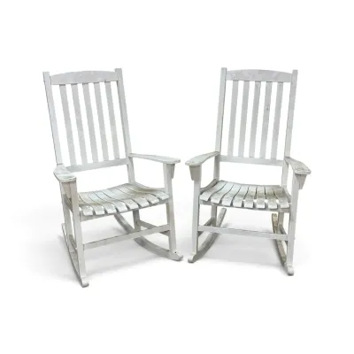Sale Photo Thumbnail #182: Pair of white painted wooden rocking chairs with slatted backs and contoured seats, showing moderate weathering and wear.