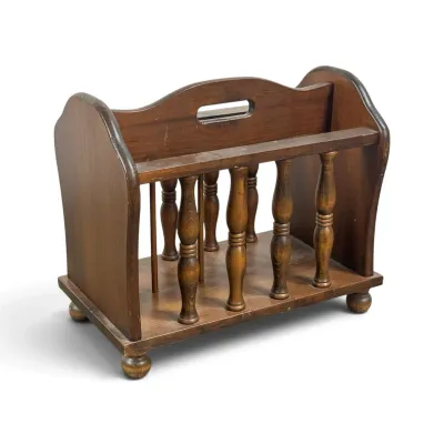 Sale Photo Thumbnail #110: Vintage mid-century wooden magazine rack featuring turned spindle details, a central carrying handle, and small ball feet.