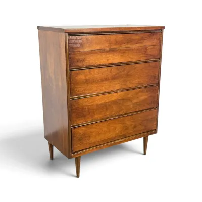 Sale Photo Thumbnail #69: Mid-century modern walnut four-drawer chest of drawers, featuring integrated wooden drawer pulls and tapered peg legs.