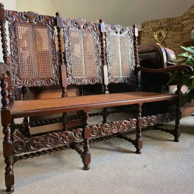 Sale Photo Thumbnail #14: Antique Jacobean-style carved oak bench featuring a three-panel cane back, cane seat, barley twist legs, and ornate floral carvings.
