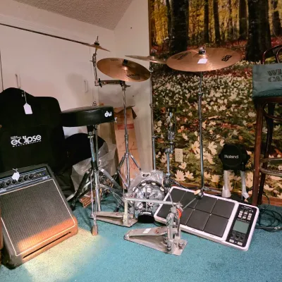 Assorted drum hardware and electronic percussion gear, including a Roland Octapad SPD-30, DW drum throne, Sabian cymbals, and an acoustic...
