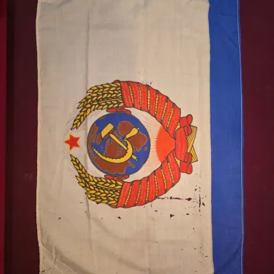 Sale Photo Thumbnail #25: Vintage Soviet-era flag featuring the State Emblem of the Soviet Union, dated 1982 on the header, with a blue vertical stripe on the fly end.
