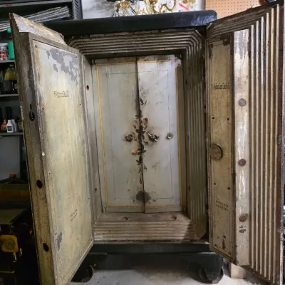 Antique Mosler double-door iron floor safe, featuring hand-painted floral detailing on the inner compartment doors and showing...