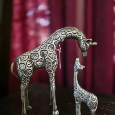 Pair of cast metal or pewter giraffe figurines, featuring intricate textured spot patterns and depicting an adult and calf.