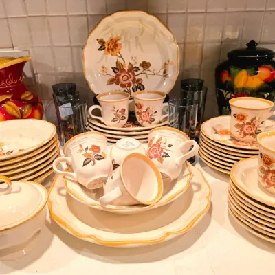 Vintage Mikasa ceramic dinnerware set featuring warm floral motifs with matching teacups, saucers, and serving pieces.