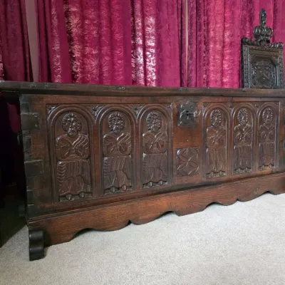 Sale Photo Thumbnail #2: Antique carved oak coffer chest featuring relief panels of figures in arched niches, with a scalloped base and iron lock mechanism.