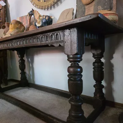 Sale Photo Thumbnail #47: Antique Jacobean-style dark oak console table featuring heavy turned legs, a carved apron, and a lower stretcher base, styled with various eclectic decorative objects.