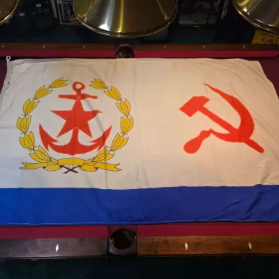 Sale Photo Thumbnail #29: Vintage Soviet Navy auxiliary vessel flag, featuring a red star and anchor within a yellow wreath alongside a red hammer and sickle on a white field with a blue bottom stripe.