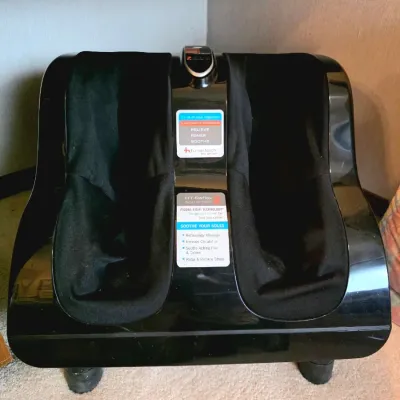 Human Touch HT-Reflex foot and calf massager featuring a black plastic housing with cloth-lined wells and control decals.