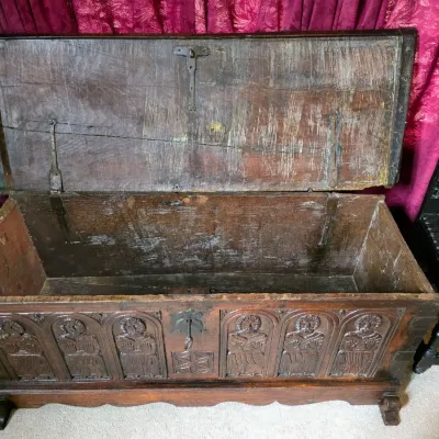Sale Photo Thumbnail #3: Antique carved oak coffer or blanket chest featuring an open lid, iron hardware, and a front panel detailed with six carved figures in arched niches.