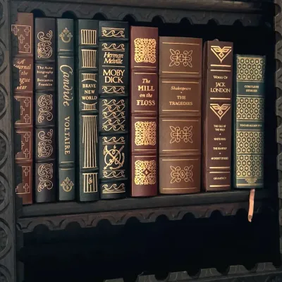 Sale Photo Thumbnail #50: Collection of classic literature books with decorative faux-leather and cloth bindings, featuring gold gilt lettering and ornate spine designs.