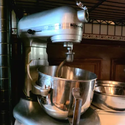 Silver KitchenAid Professional HD bowl-lift stand mixer with a stainless steel mixing bowl and dough hook attached.