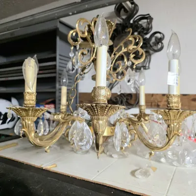 Vintage brass multi-arm chandelier adorned with clear cut glass crystal prisms.
