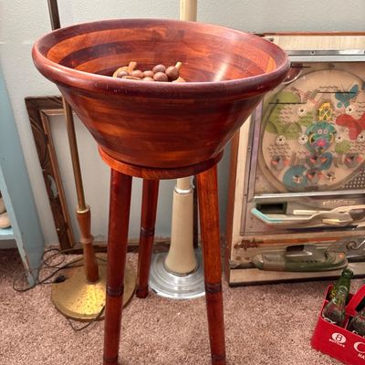 Sale Photo Thumbnail #271: Mid-century modern wooden salad bowl on a matching three-legged stand, featuring a warm reddish-brown finish.