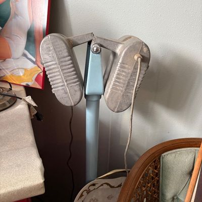 Sale Photo Thumbnail #280: Vintage mid-century electric massager on a light blue pedestal stand, featuring dual ribbed aluminum massage heads.
