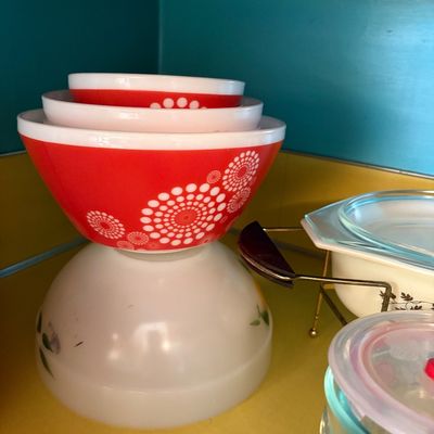 Sale Photo Thumbnail #204: Vintage Pyrex nesting bowls in the orange and white 'Dots' pattern, stacked on a shelf alongside other mid-century kitchenware.