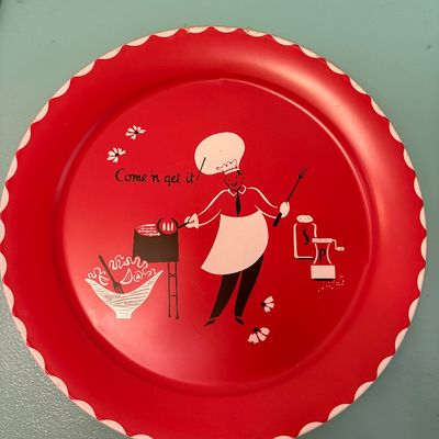 Sale Photo Thumbnail #225: Vintage mid-century red metal barbecue platter featuring a whimsical chef illustration and the phrase "Come 'n get it!" with a scalloped white border.