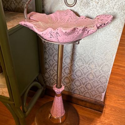 Mid-century modern pink and gold splatter-glazed ceramic ashtray stand with a brass pedestal base and integrated carrying handle.