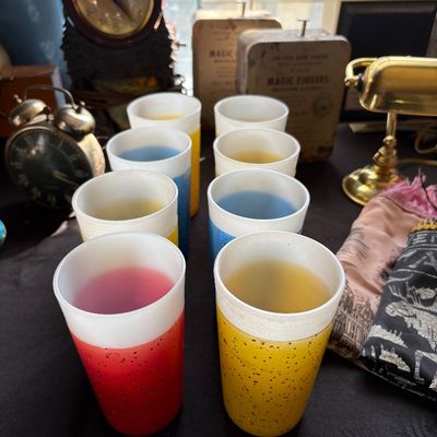 Sale Photo Thumbnail #156: Vintage mid-century plastic tumblers with glitter accents in assorted colors, displayed alongside vintage clocks and a brass desk lamp.