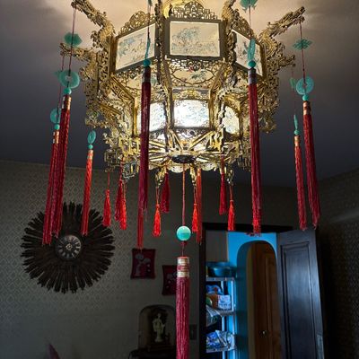 Ornate Chinese-style palace lantern chandelier featuring a gilded metal frame with dragon motifs, painted glass panels, and hanging red...