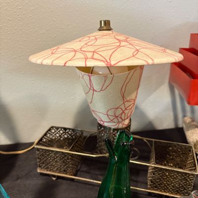 Sale Photo Thumbnail #300: Mid-century modern desk lamp with a fiberglass shade featuring a red squiggle pattern, mounted on a brass wire base with dual mesh organizer cups.