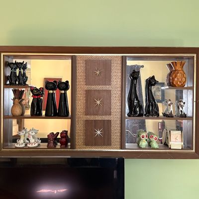 Mid-century modern shadow box wall shelf featuring starburst accents and a collection of vintage ceramic cat figurines.