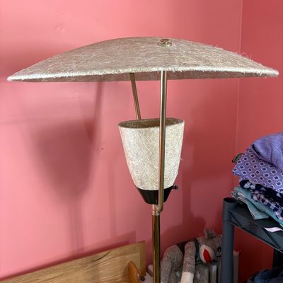 Sale Photo Thumbnail #122: Mid-century modern floor lamp featuring a brass pole, a textured fiberglass cone shade, and a matching wide fiberglass saucer shade.