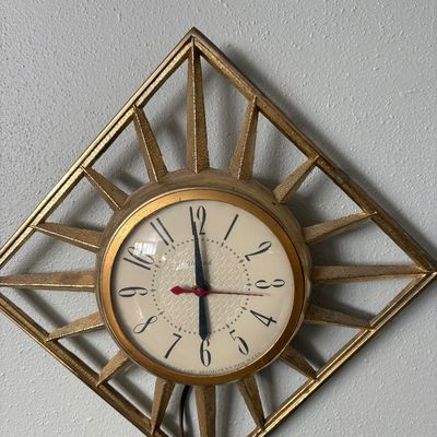 Sale Photo Thumbnail #282: Mid-century modern United Clock Corp. electric wall clock featuring a gold-toned diamond starburst frame, made in Brooklyn, NY.