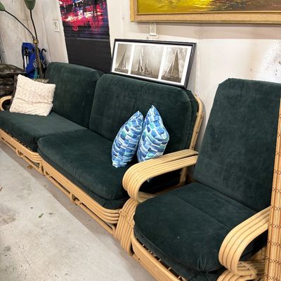 Sale Photo Thumbnail #407: Vintage mid-century modern rattan living room set, including a three-seat sofa and matching armchair, featuring dark green upholstered cushions.