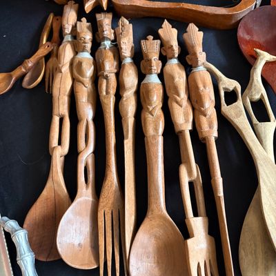Sale Photo Thumbnail #261: Collection of hand-carved African wooden serving utensils, featuring detailed figural handles with wire neck accents.