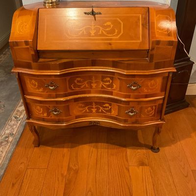 Italian-style marquetry slant-front secretary desk featuring a serpentine front, two drawers with ornate brass pulls, and cabriole legs.