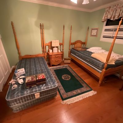 Pair of vintage pine four-poster twin beds, accompanied by a matching three-drawer nightstand. Dresser,  and a small green patterned area...