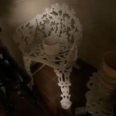 Vintage white cast iron garden chair with an ornate grape and leaf motif with matching table. 