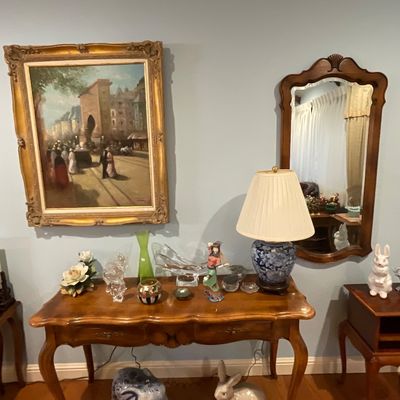 French Provincial style console table with cabriole legs, displaying various decorative items including a blue and white ceramic lamp,...