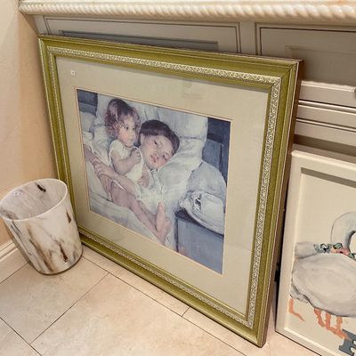 Framed print of Mary Cassatt's "Breakfast in Bed," housed in an ornate gold-finished frame with a wide mat.
