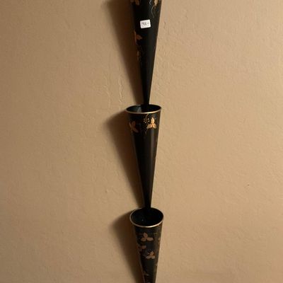 Vintage mid-century black metal three-tier cone wall planter featuring hand-painted gold leaf details.