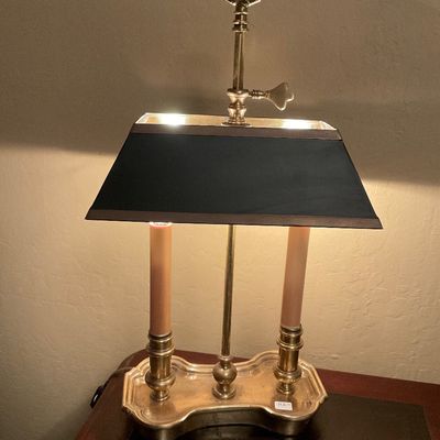 Vintage brass bouillotte lamp with a black metal shade, featuring two faux-candle lights and an adjustable central key mechanism.
