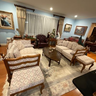 Dreel Heritage living room set featuring two matching love seats with patterned upholstery and exposed wood frames, and an oval wooden...