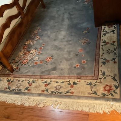 Vintage Chinese Art Deco style wool rug featuring a muted blue field with floral motifs and a fringed border.
