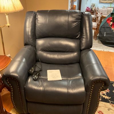 Dark blue leather power lift recliner featuring brass nailhead trim, dual remote controls, massage feature and the original user manual....