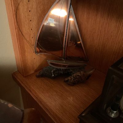 Vintage stained glass sailboat sculpture mounted on a natural driftwood base.