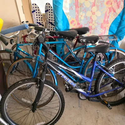 Sale Photo Thumbnail #91: Trek 800 mountain bike in blue and black, shown alongside vintage Schwinn World Tourist road bikes and various outdoor gear.