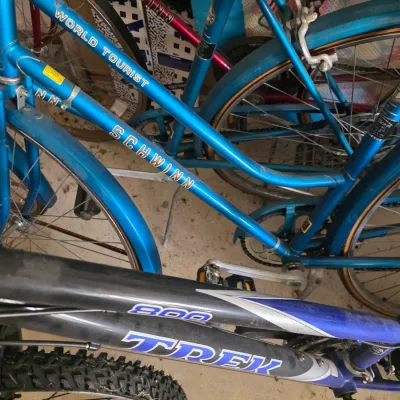 Sale Photo Thumbnail #93: Vintage blue Schwinn World Tourist bicycle shown alongside a modern Trek 800 mountain bike.