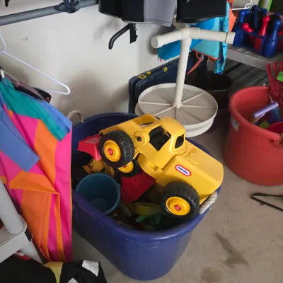 Sale Photo Thumbnail #88: Little Tikes yellow toy dump truck resting on top of a blue plastic storage tub filled with various beach and outdoor toys.