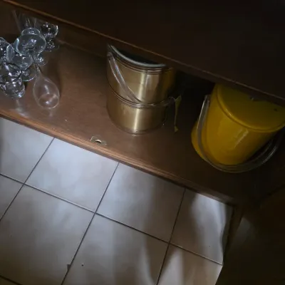 Sale Photo Thumbnail #27: Mid-century modern barware including a yellow vinyl ice bucket, a brass ice bucket, and assorted glassware stored in a wooden cabinet.