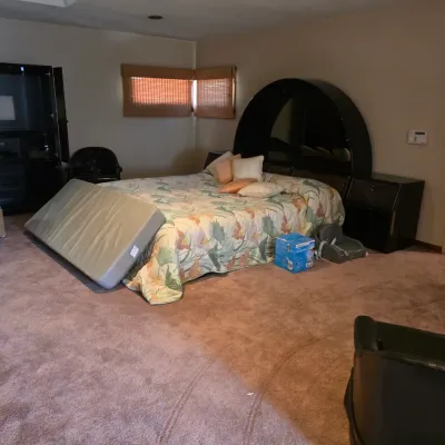 Sale Photo Thumbnail #112: Retro 1980s black laminate bedroom set featuring a platform bed with a large arched headboard, integrated nightstands, and a matching armoire.