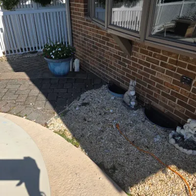 Sale Photo Thumbnail #39: Assorted outdoor garden decor, including a blue ceramic planter with flowers and small stone animal figurines placed along a brick wall.