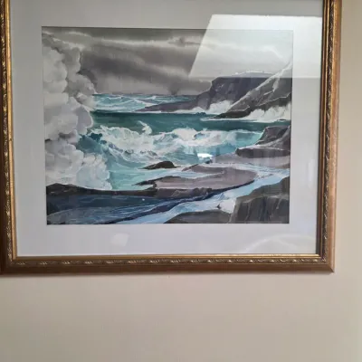 Sale Photo Thumbnail #20: Framed watercolor painting depicting a stormy seascape with crashing waves against a rocky coastline, presented in a gold-toned frame with a white mat.